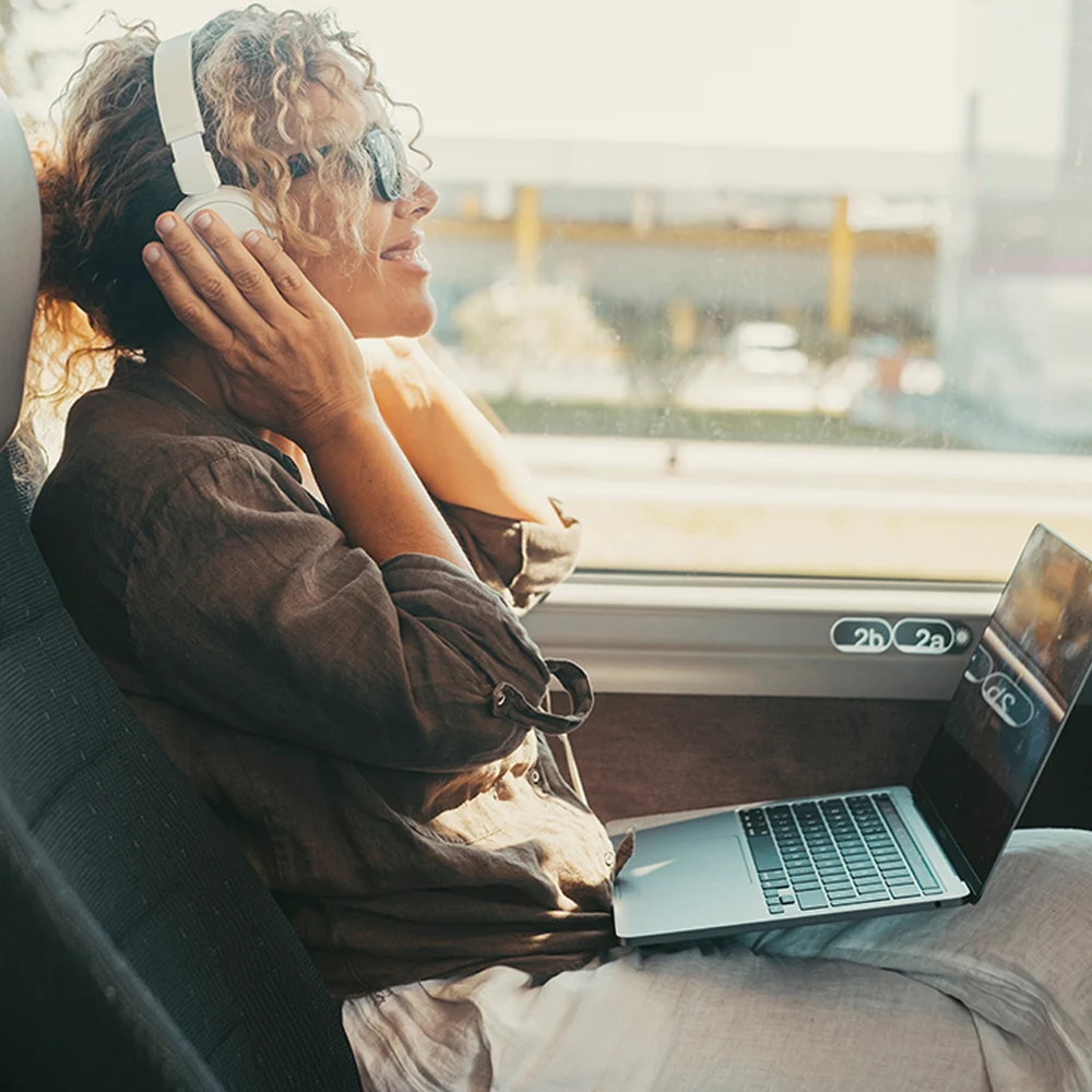 Femme souriante qui écoute de la musique en car